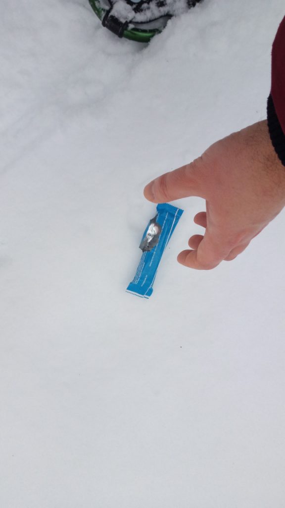 Picture of my hand reaching for garbage on the side of the trail